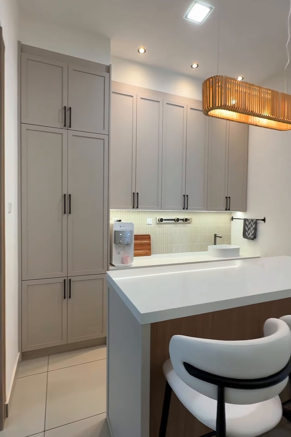 Greige shaker-style dry kitchen with floor-to-ceiling cabinets, quartz-top movable island and bar stools, Taman Daiman, Johor Bahru